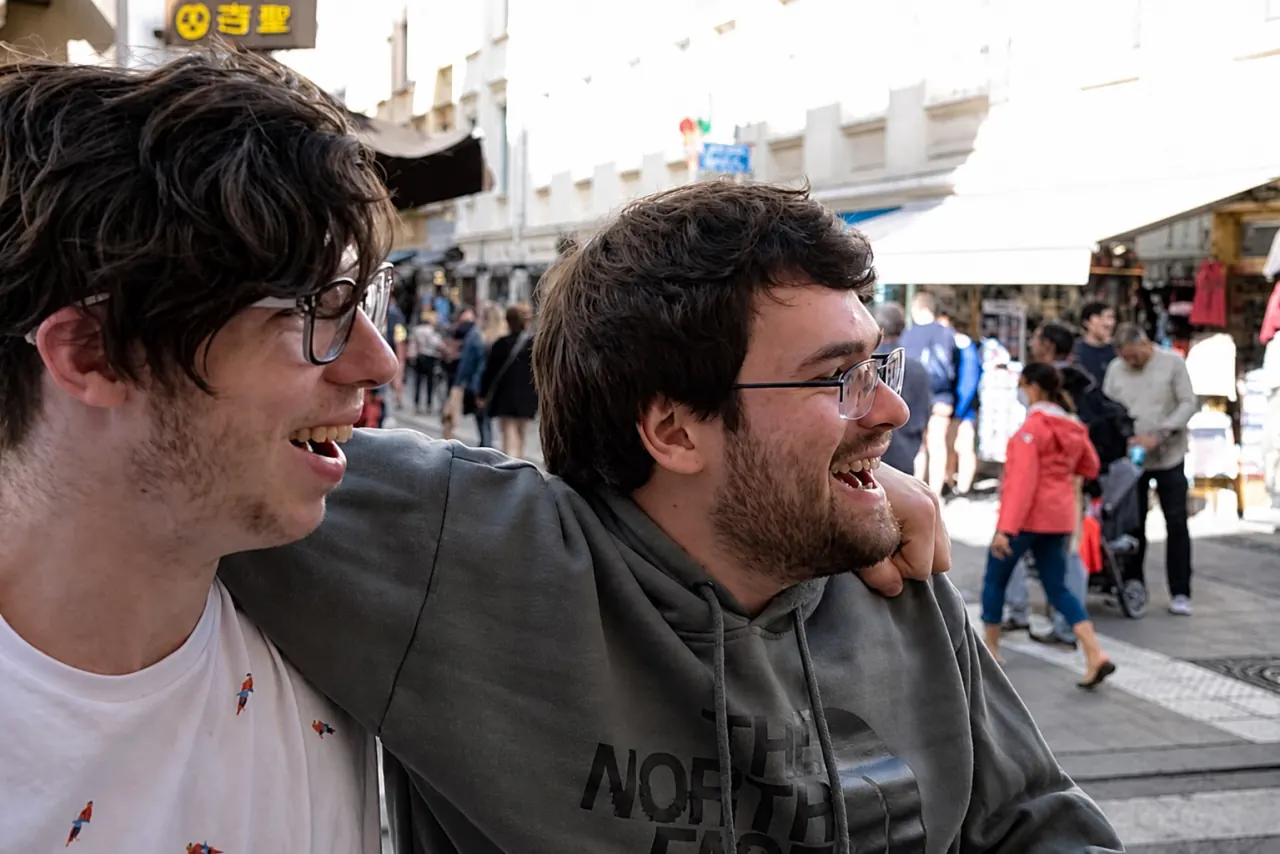 Two WanderRock travelers laughing together on a street in Europe