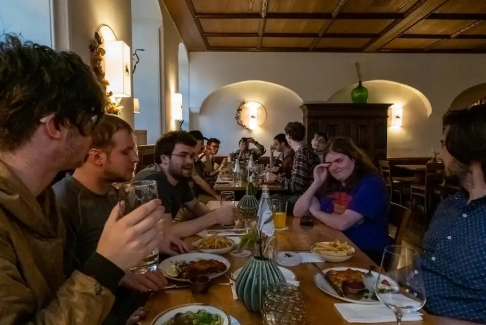 A WanderRock group at a long table over dinner in Europe