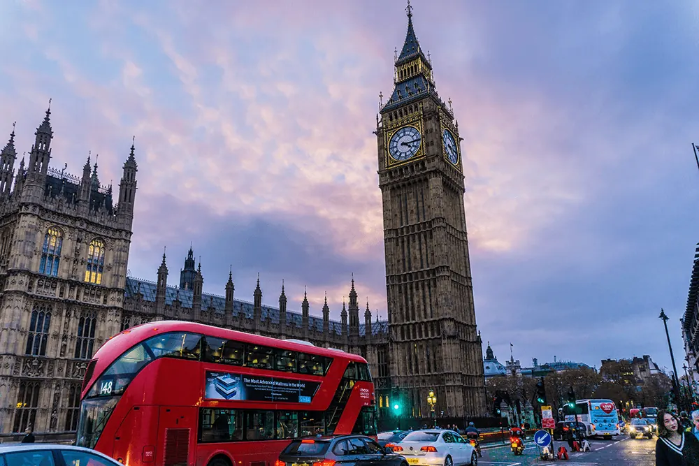 Big Ben above a red double-decker bus in London